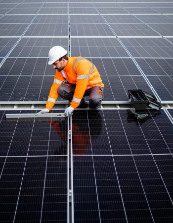Professional worker checking level and installing solar panel modules on rooftop for sustainable energy. Professional worker checking level and installing solar panel modules on rooftop for sustainable energy.